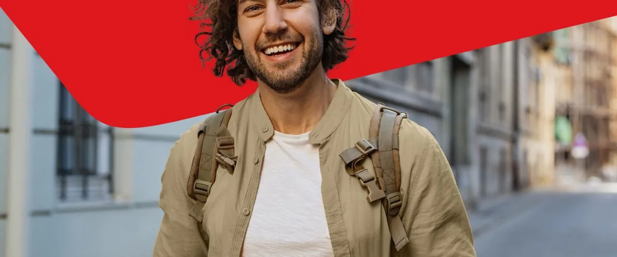 A person smiling while looking at a phone beside a National Bank promotion panel.