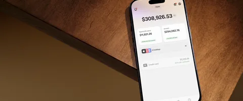 An iPhone displaying the Wealthsimple app on a wooden tabletop.